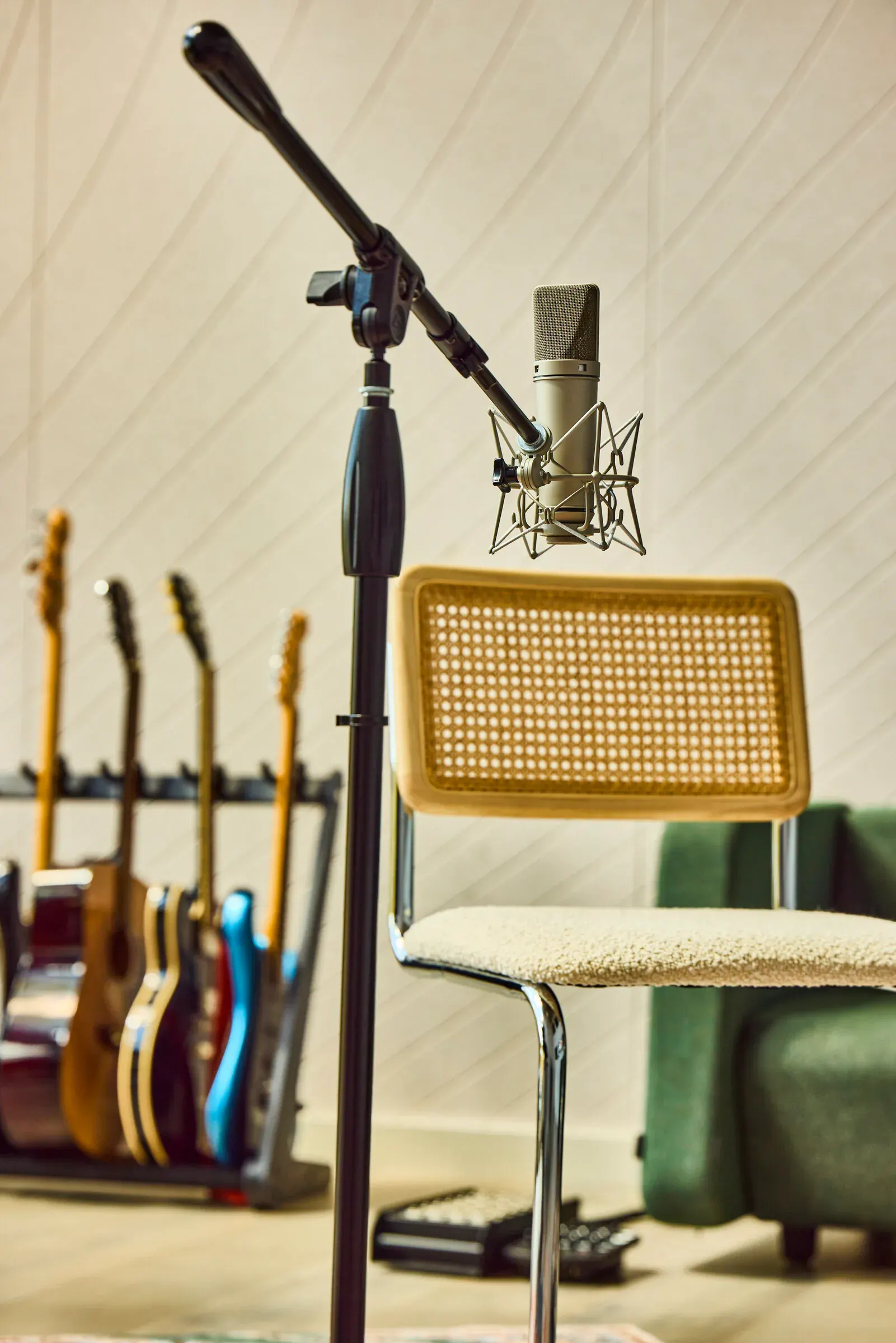 Neumann condenser microphone on stand with guitar rack in the Verdant Sound live room