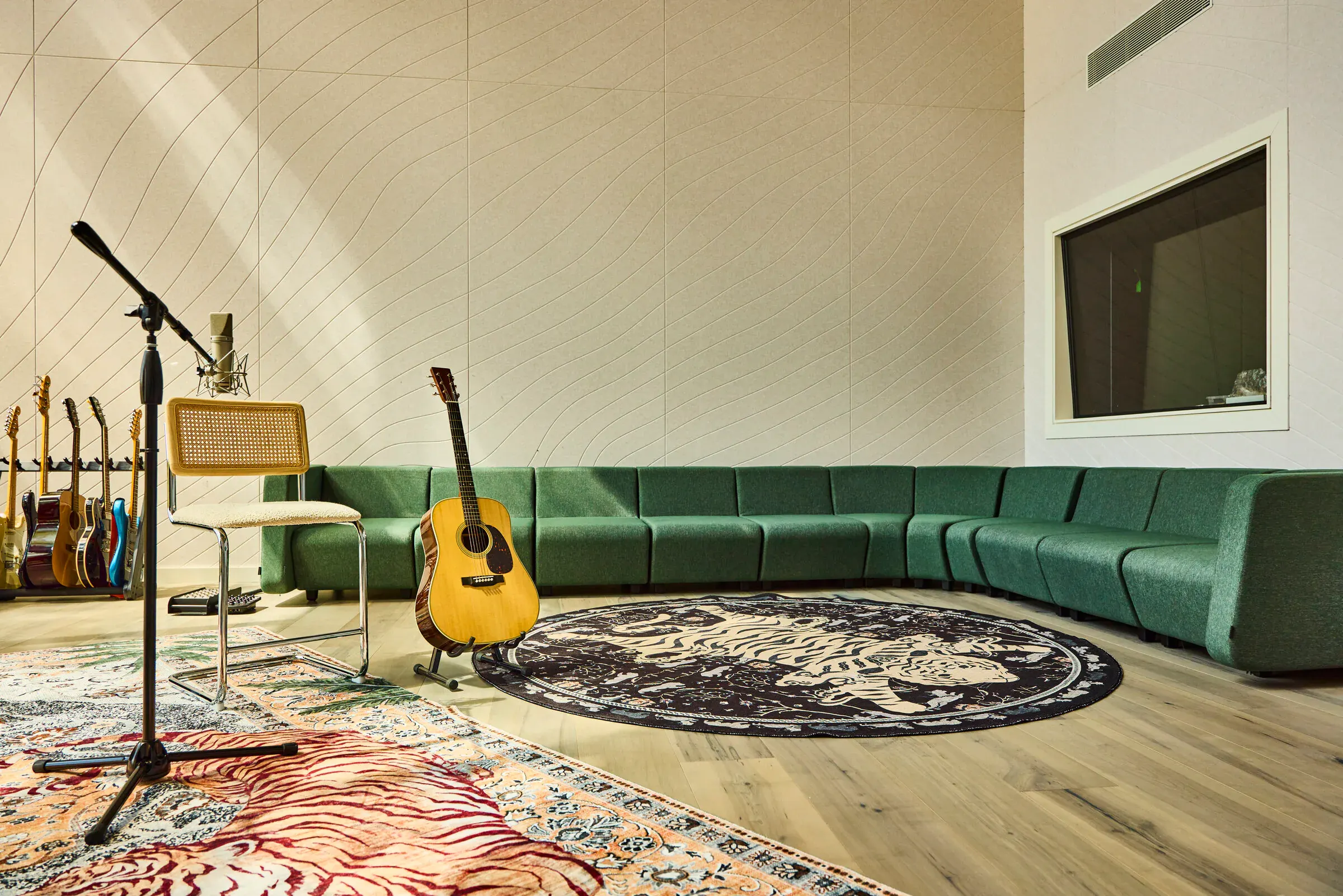 Green velvet sectional sofa and guitar rack in the Verdant Sound live room